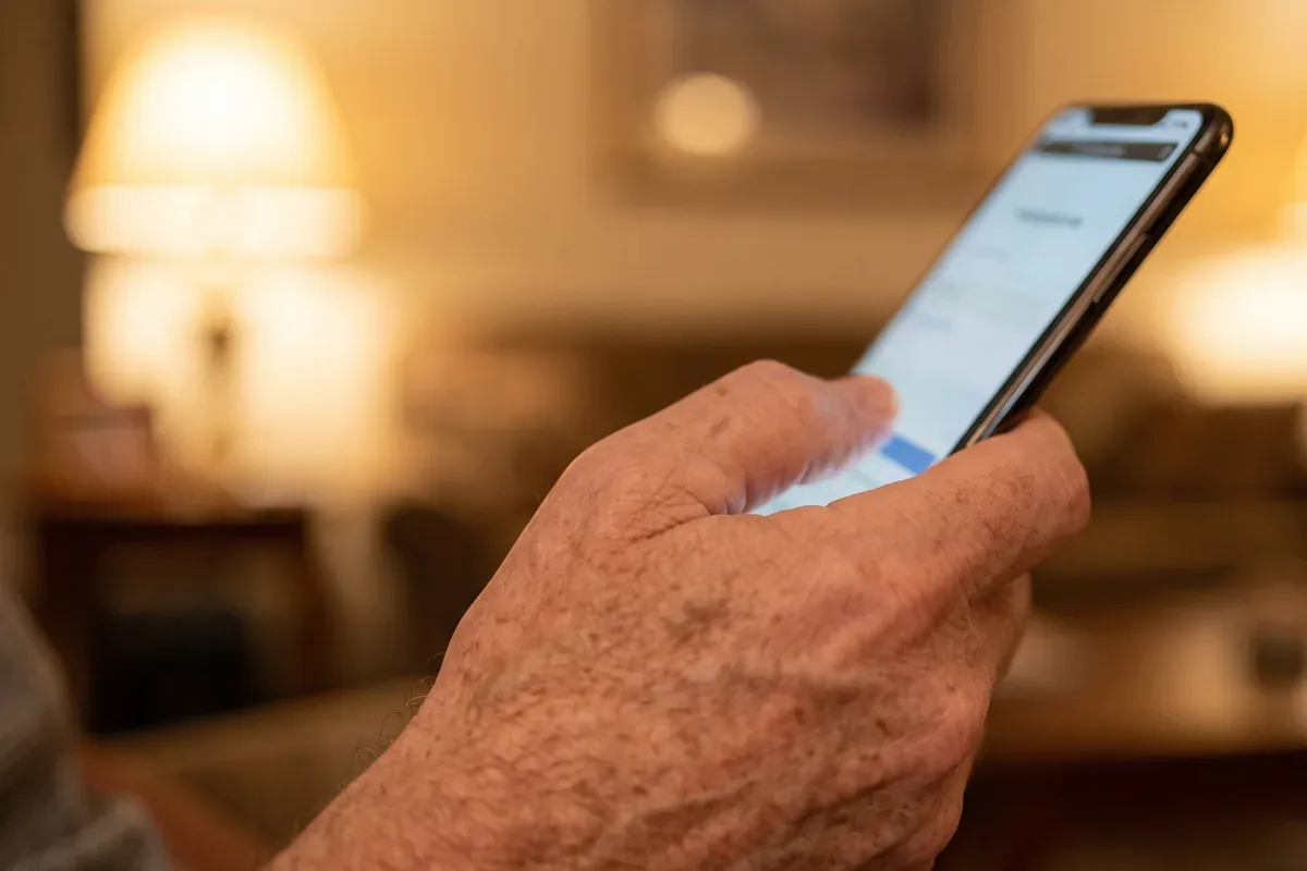 Close-up of a man's thumb confirming a sign-in with his fingerprint on a phone